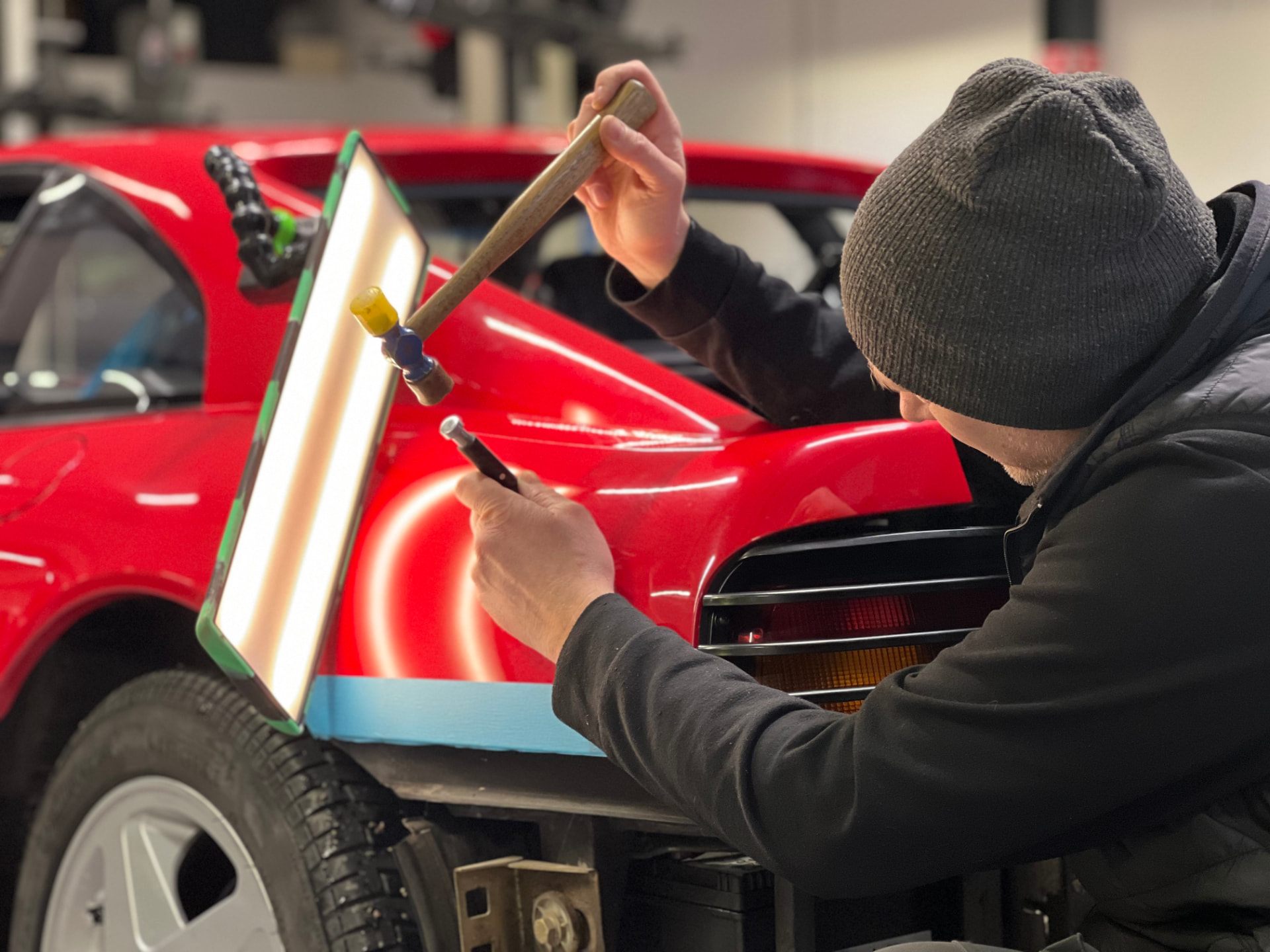 Parkeringsskador — tekniker arbetar med PDR på röd Ferrari